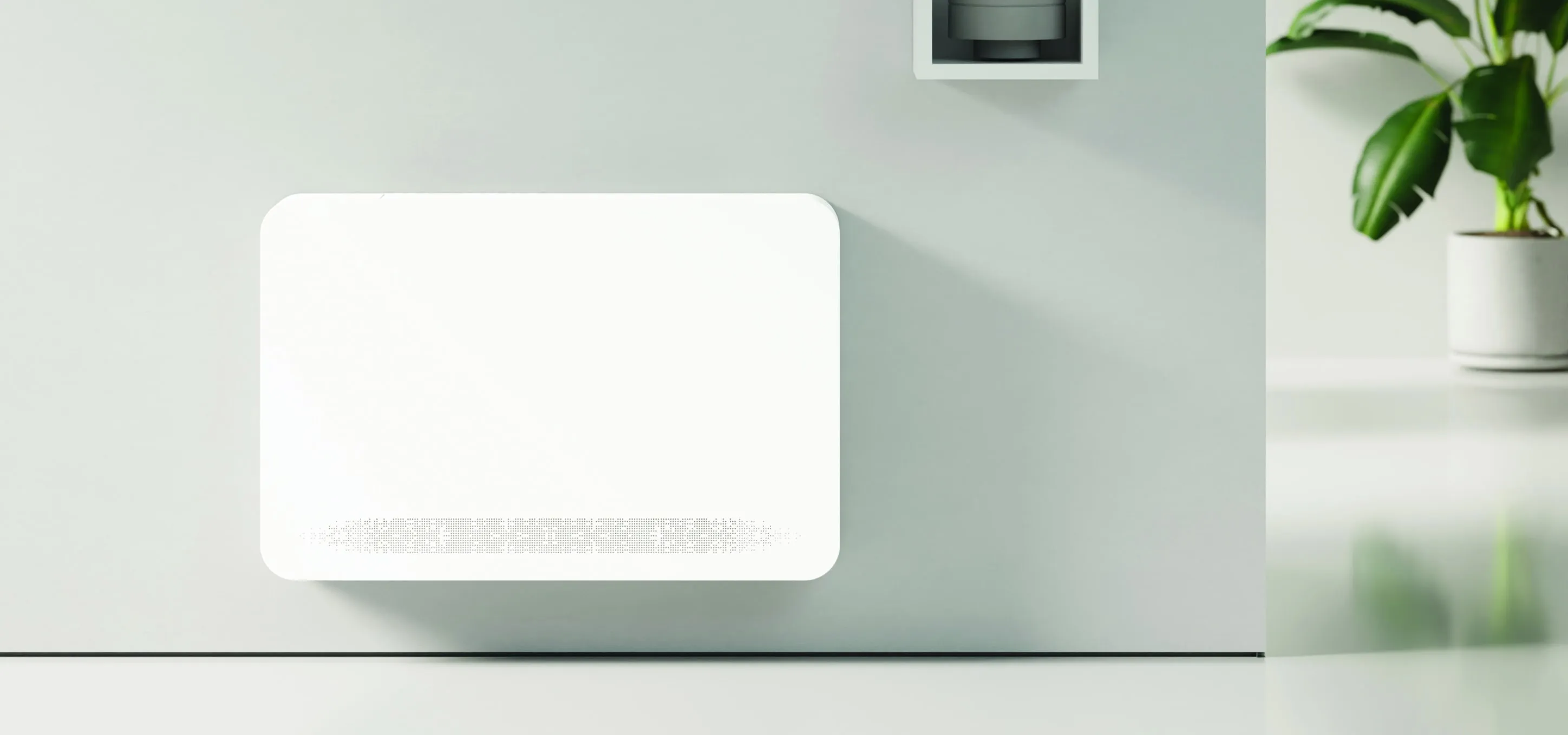 LOOP Wall Mounted unit on a soft-lit wall beside a plant
