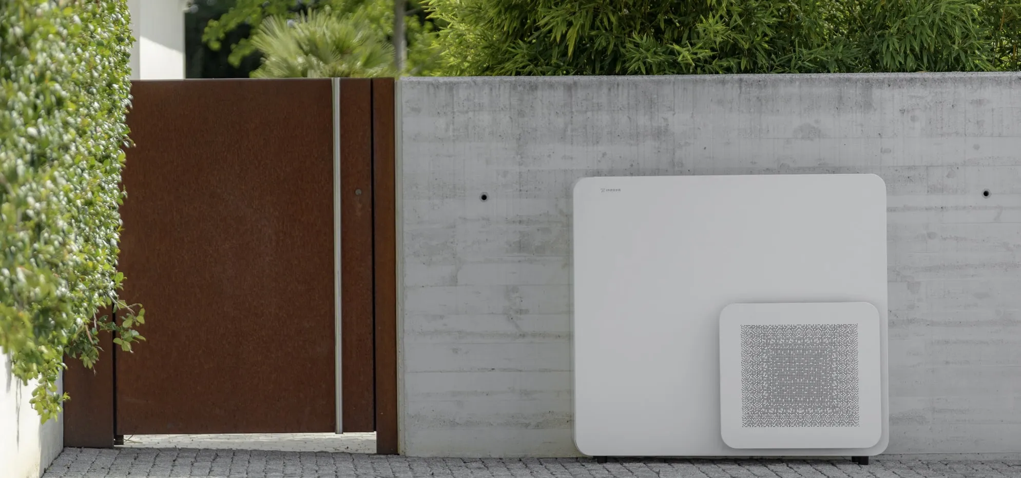 STØNE Architectural outdoor unit standing against a concrete garden wall