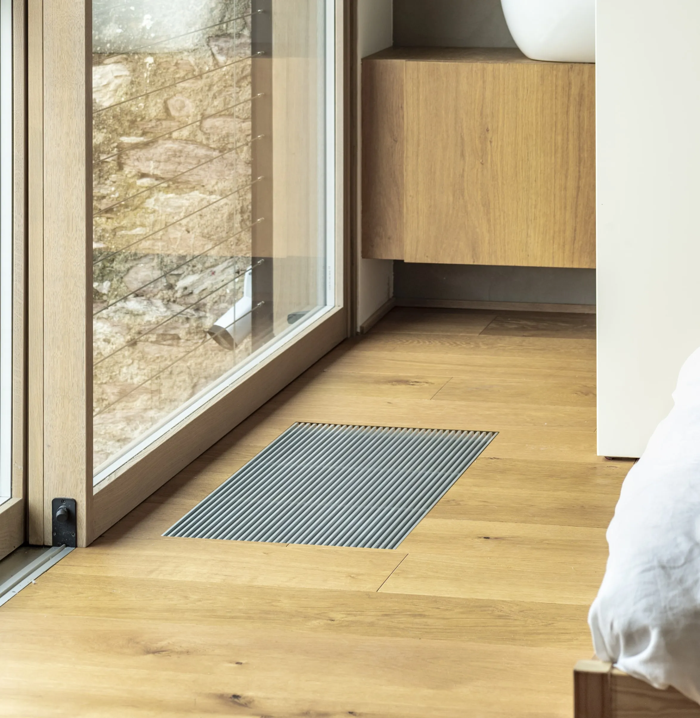 An OSMO recessed-floor unit beside a glass door onto a terrace