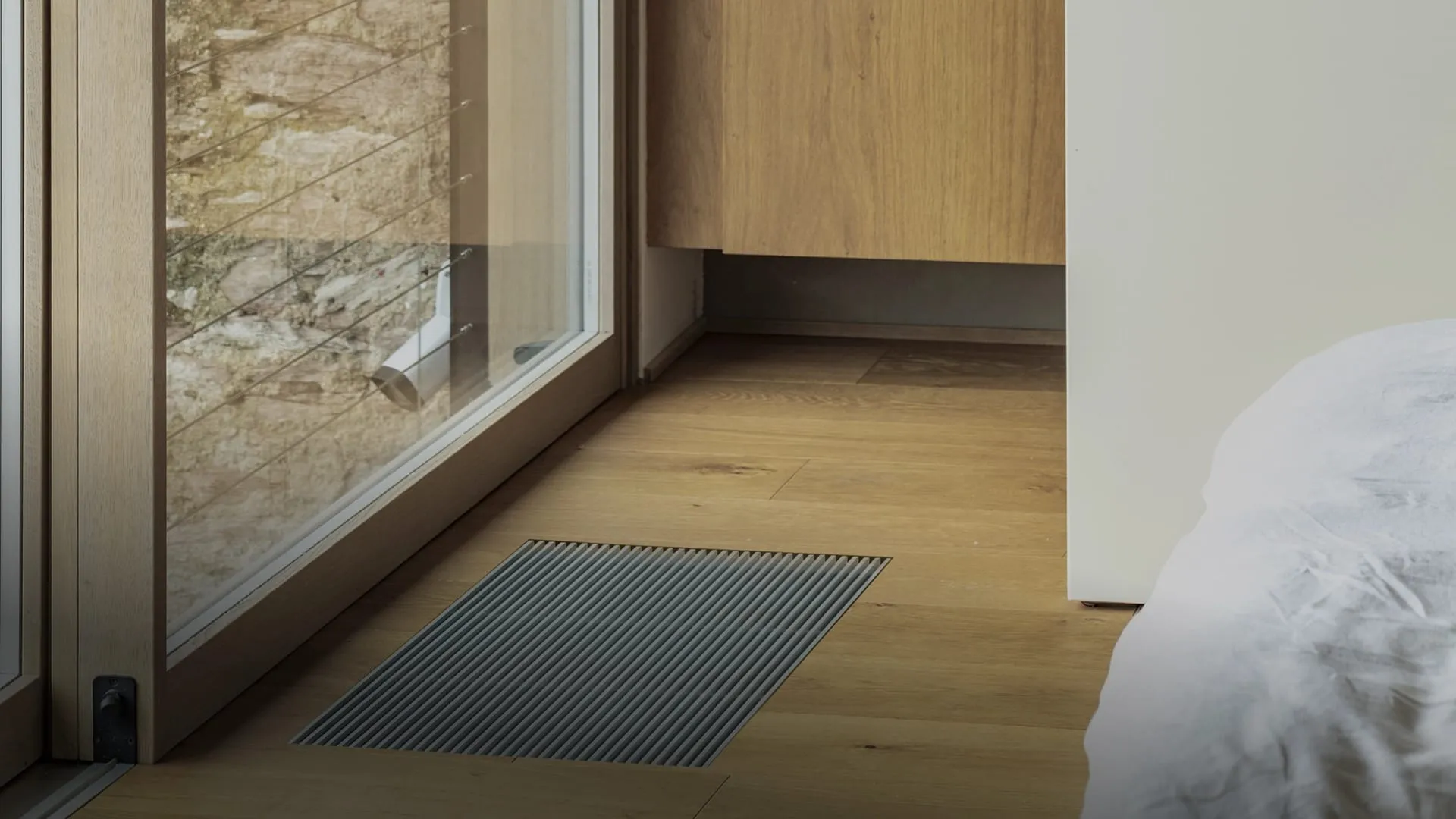 OSMO Frameless Trench grille set into the floor by a window wall