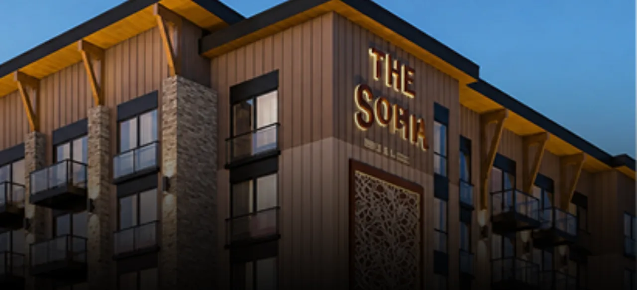Exterior of The SOMM Hotel at dusk — a stone and timber façade with no visible HVAC equipment